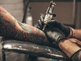 Close up of tattoo artist tattooing someone's arm.