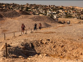 Tourists visit the pre-historic site of Tell al-Sultan, near the Palestinian city of Jericho