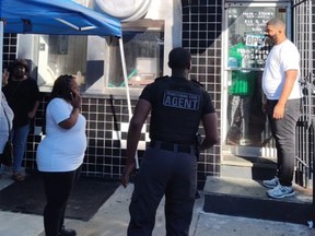 Armed security stands outside Jim’s West Steaks & Hoagies restaurant in Philadelphia.