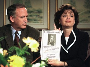 John Ramsey looks on as his wife, Patsy, holds an advertisement promising a reward for information leading to the arrest and conviction of the murderer of their six-year-old daughter, JonBenet, in this May 1, 1997 file photo, in Boulder, Colo.