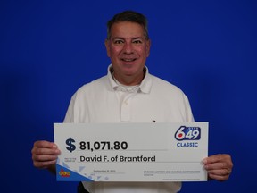 Lottery winner holding cheque with $81,071.80 on it.