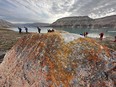 Ancient lichen and much younger Adventure Canada hikers at Cuming Inlet.