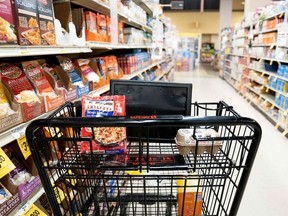 A grocery cart sits in an aisle at a grocery store