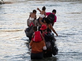 Migrants cross the Rio Grande