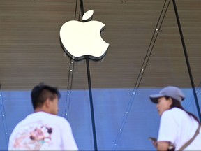 People stand outside an Apple store in Beijing on Sept. 12, 2023.