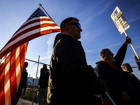 UAW members Dan Schlieman, with flag, and Brad Geer work the picket line during a strike Tuesday, Sept. 19, 2023, at the Stellantis Toledo Assembly Complex where Jeeps are made in Toledo, Ohio.