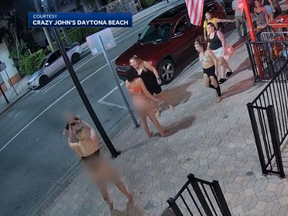 In a screengrab from video a woman holds a baby during an altercation in Daytona Beach.