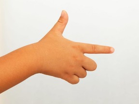 A child's hand making a "finger gun" gesture.