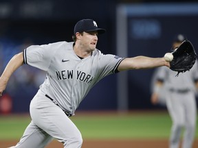 Yankees starter Gerrit Cole grabs a bouncing ball.