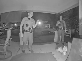 Screenshot of doorbell camera footage of two cops on porch