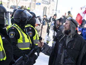 As thousands of demonstrators clogged the streets around Parliament Hill in early 2022, many of them did so with a phone in their hand. A protester records a police line with their phone as police move in to clear downtown Ottawa near Parliament Hill of protesters after weeks of demonstrations on Saturday, Feb. 19, 2022.