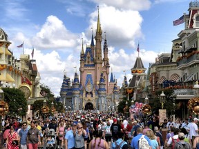 FILE - Crowds fill Main Street USA in front of Cinderella Castle at the Magic Kingdom on the 50th anniversary of Walt Disney World, in Lake Buena Vista, Fla., on Oct. 1, 2021. Facing backlash, Walt Disney World's governing district will pay a stipend to employees whose free passes and discounts to the theme park resort were eliminated under a policy made by a new district administrator and board members who are allies of Florida Gov. Ron DeSantis.