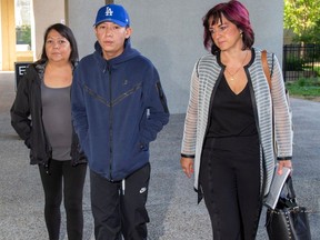 Pacey Dumas, centre, enters the Edmonton courthouse on Sept. 11, 2023, with mother Irene Dumas, left, and lawyer Lawyer Heather Steinke-Attia. Pacey Dumas swore a private information against EPS Const. Ben Todd, who kicked him in the head during an arrest in 2020 — the first step in launching a private prosecution.