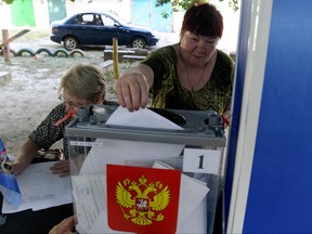 A woman casts her ballot at a mobile polling station during early voting for local elections organized by the Russian-installed authorities in Donetsk, Russian-controlled Ukraine, on Sept. 6, 2023