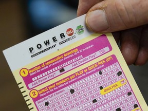 FILE - A person shows his scan card for their personal selection numbers for a ticket for a Powerball drawing on Nov. 7, 2022 in Renfrew, Pa. An $835 million Powerball jackpot will be up for grabs Wednesday, Sept. 27, 2023, for players willing to risk a couple dollars and brave incredibly long odds.