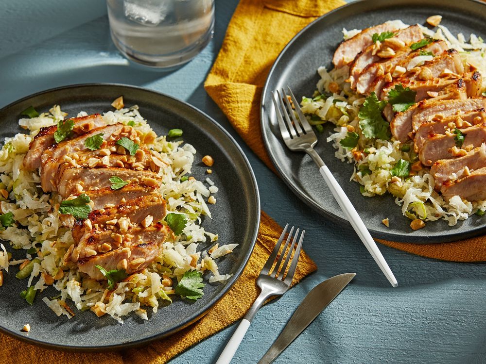 Schweinekoteletts und ein Jicama-Apfel-Krautsalat glänzen mit ...