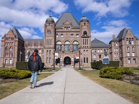 A man walks in front of Queen's Park in Toronto, Monday, Feb. 20, 2023.
