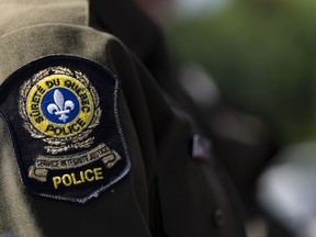 A Quebec provincial police emblem is seen on an officer's uniform in Montreal, Tuesday, Aug. 22, 2023. Quebec provincial police say they've made three arrests after human remains were found in the Quebec City area on Sunday.
