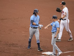 Tampa Bay Rays' Tristan Gray, left, reacts with first base coach Chris Prieto after collecting his first major league hit in the fifth inning of a baseball game against the Baltimore Orioles, Sunday, Sept. 17, 2023, in Baltimore.