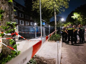 The police and fire brigade stand outside the building where a 32-year-old man shot a 39-year-old woman and her 14-year-old daughter, in Rotterdam, on Sept. 28, 2023.