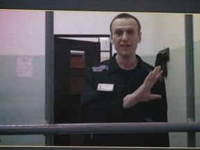 Russian opposition leader Alexei Navalny, is seen on a TV screen as he appears in a video link provided by the Russian Federal Penitentiary Service from the colony in Melekhovo, Vladimir region, during a hearing at the Russian Supreme Court in Moscow, Russia, on Wednesday, Aug. 23, 2023.