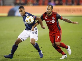 Toronto FC's Victor Vazquez battles for the ball with New England Revolution's Brandon Bye during the second half of MLS soccer action in Toronto, Saturday September 29, 2018. Vazquez is looking forward to a reunion Wednesday with Lionel Messi in Florida, having . risen through the ranks with Messi at FC Barcelona's famed youth academy.