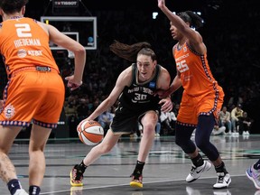 New York Liberty forward Breanna Stewart, center, drives to basket against Connecticut Sun forward Alyssa Thomas during the fourth quarter of a WNBA basketball game Sunday, Sept. 24, 2023, in New York.