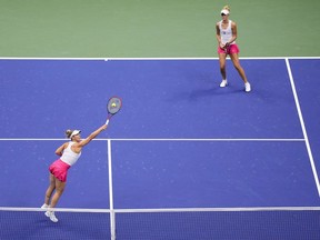 Gabriela Dabrowski, of Canada, left, returns a shot alongside doubles partner Erin Routliffe, of New Zealand, during the women's doubles final of the U.S. Open tennis championships against Laura Siegemund, of Germany, and Vera Zvonareva, of Russia, Sunday, Sept. 10, 2023, in New York.