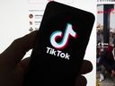 FILE - The TikTok logo is seen on a mobile phone in front of a computer screen which displays the TikTok home screen, Saturday, March 18, 2023, in Boston. A report released Thursday, Sept. 28, by a tech watchdog group said TikTok has become a key marketing channel for vendors that want to promote steroids and other bodybuilding drugs to millions of people who use the app.