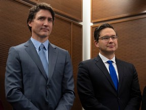 Prime Minister Justin Trudeau stands with Conservative leader Pierre Poilievre as he waits to speak at a Tamil heritage month reception, Monday, Jan. 30, 2023 in Ottawa.