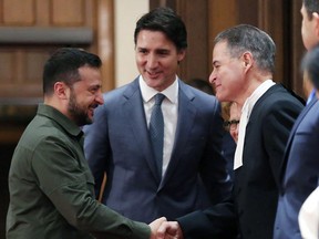 Ukrainian President Volodymyr Zelensky, with Prime Minister Justin Trudeau (centre), shake hands with House of Commons Speaker Anthony Rota during a ceremony on Parliament Hill on Sept. 22, 2023 in Ottawa.