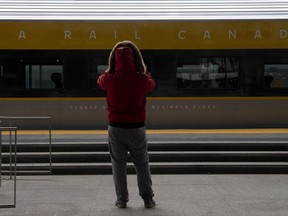 A person takes a photo of a new Via Rail train