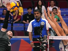 Canada's Stephen Timothy Maar, left, hits the ball during their game against Italy at the Men's Volleyball Nations League leg in Manila, Philippines on Thursday July 6, 2023.&ampnbsp;Canada emerged victorious in its opening match of a men's volleyball Olympic qualification tournament early on Saturday.