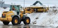 Heavy equipment operators in front-end-loaders clear snow in Quinte's retail parking lots, including those along Bell Blvd., in Belleville.