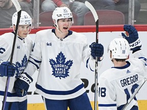 Fraser Minten (39) des Maple Leafs de Toronto célèbre avec ses coéquipiers Nick Abruzzese (26) et Noah Gregor (18) après avoir obtenu leur score contre les Canadiens de Montréal.