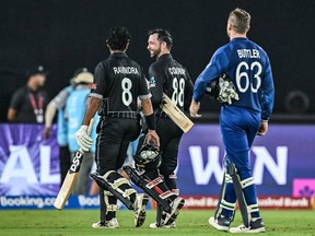 New Zealand's Rachin Ravindra (left), Devon Conway and England's captain Jos Buttler walk back to the pavilion at the end of the cricket World Cup match.