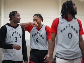 Toronto Raptors' Scottie Barnes (4) jokes with O.G. Anunoby (3) as they stand behind Javon Freeman-Liberty (0) during the opening day of the NBA basketball team's training camp.
