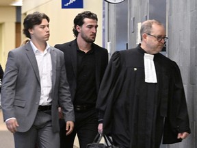 Former Victoriaville Tigres junior major hockey league players Nicolas Daigle, left, and Massimo Siciliano, follow defense lawyer Michel Lebrun, right, leave the courtroom.