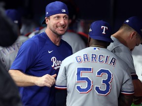 Adolis Garcia celebrates with Max Scherzer of the Texas Rangers after defeating the Tampa Bay Rays.