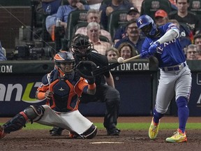 Texas Rangers' Adolis Garcia hits a grand slam during the ninth inning of Game 6 of the ALCS against the Houston Astros.