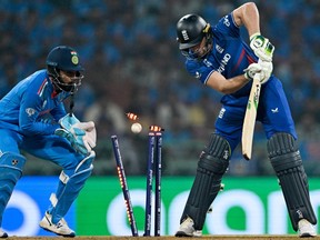 England's captain Jos Buttler is clean bowled as India's KL Rahul watches.