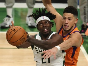 Jrue Holiday is defended by Devin Booker.