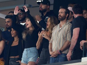 Singer Taylor Swift, from left, and actors Blake Lively, Ryan Reynolds and Hugh Jackman watch an NFL game.