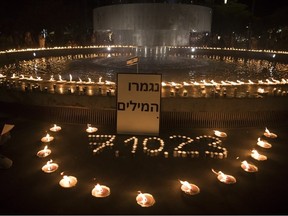 Une pancarte disant en hébreu « Plus de mots » près de bougies allumées par des personnes en mémoire des civils et des soldats tués, et des otages emmenés dans la bande de Gaza, est visible en Israël le 12 octobre 2023.