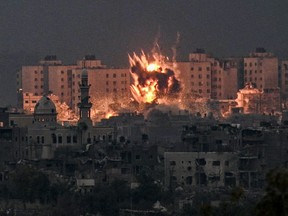 A fireball erupts during Israeli bombardment in the northern Gaza Strip on Saturday, Oct. 14, 2023.
