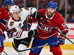 Connor Bedard of the Chicago Blackhawks and David Savard of the Montreal Canadiens skate into each other.