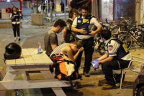 A young woman reacts as she speaks to Israeli rescuers in Tel Aviv, after a building was hit by a rocket fired by Palestinian militants from the Gaza Strip on Oct. 7, 2023.