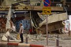 A man stands in front of a damaged shop in Tel Aviv, after it was hit by a rocket fired by Palestinian militants from the Gaza Strip on Oct. 7, 2023.