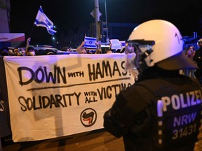 Riot police stand by as demonstrators in support of Israel display a banner.