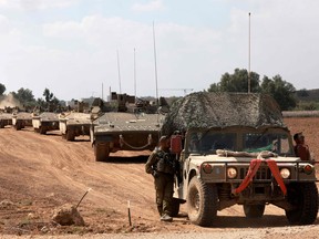 A convoy of Israeli army vehicles is pictured along the border with the Gaza Strip in southern Israel on October 13, 2023. (Photo by MENAHEM KAHANA/AFP via Getty Images)